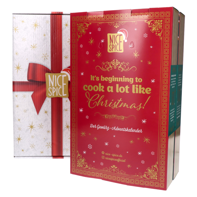 Klappbarer NICE SPICE Adventskalender im Buch-Stil, Ansicht der zugeklappten Vorderseite mit Wintermuster auf rotem Hintergrund sowie ein weißer Umkarton mit bedruckter roter Schleife im Geschenk-Stil